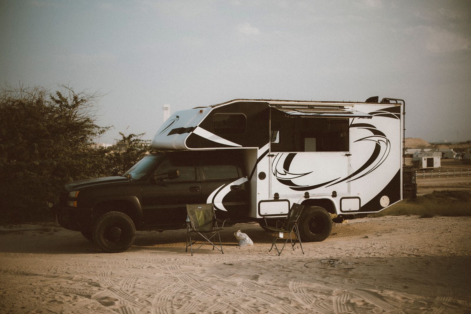 Recreational vehicle parked at a sandy campsite